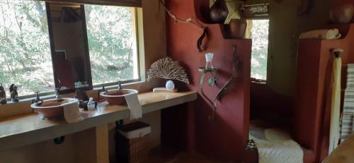 łazienka z 2 umywalkami i 2 oknami w obiekcie Canyon guest villa w mieście Hoedspruit