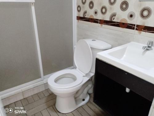 uma casa de banho com um WC branco e um lavatório. em HOSPEDAJE YACUCALLE em Ibarra