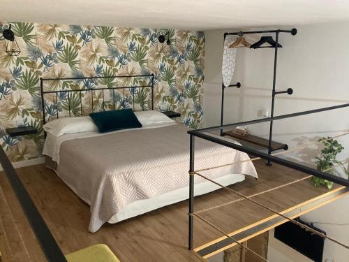 a bedroom with a bed with a floral wallpaper at Vecchio Loft con Jacuzzi in Siracusa