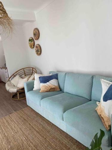 a blue couch sitting in a living room at Casa dos Avós in Vila Nova de Milfontes