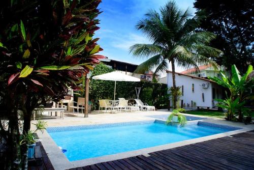 een zwembad in het midden van een tuin met een huis bij Casa Bali 1 2 3 in Niterói