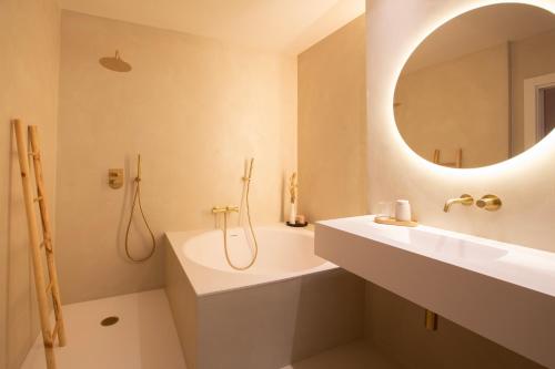 a bathroom with a sink and a tub and a mirror at Alux Boutique Hotel in Málaga