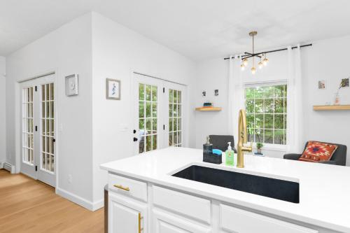 a white kitchen with a sink and a counter at Gorogeous Chic 2BDR Renovated Home near Downtown Sleeps 6 843 in Traverse City