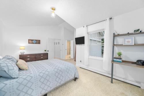 ein weißes Schlafzimmer mit einem Bett und einem Fenster in der Unterkunft Gorogeous Chic 2BDR Renovated Home near Downtown Sleeps 6 843 in Traverse City