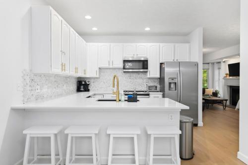 a kitchen with white cabinets and a stainless steel refrigerator at Gorogeous Chic 2BDR Renovated Home near Downtown Sleeps 6 843 in Traverse City