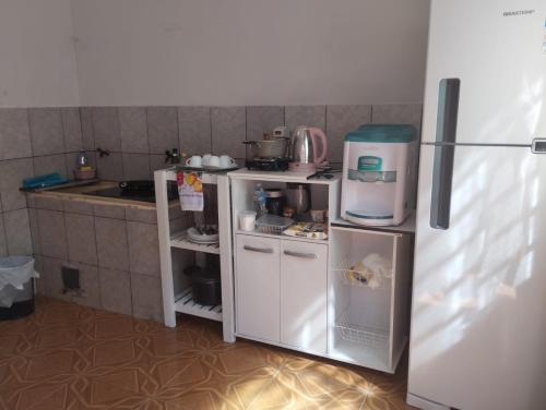 a small kitchen with a refrigerator and a counter at Pousada Guaíra in Guaíra