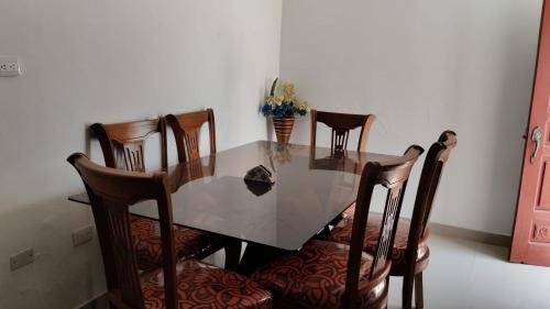 una mesa de comedor con 4 sillas y un jarrón de flores en Aparta estudio - paris, en Ciénaga