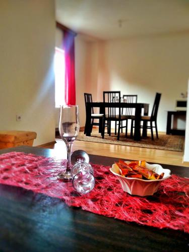 a table with a wine glass and a bowl of food at Apartman ASI in Mostar