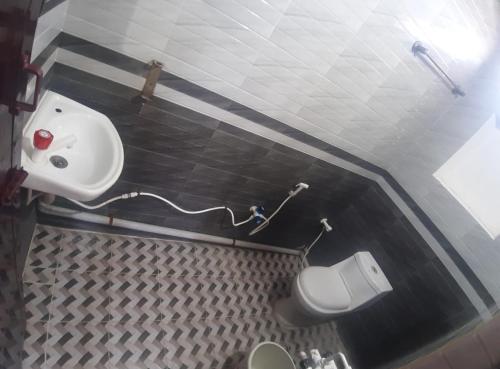 a small bathroom with a sink and a toilet at Shree SaiRenu near maruthamalai and bharathiyar univ and on the way to Adiyogi Isha Yoga centre in Marudhamalai