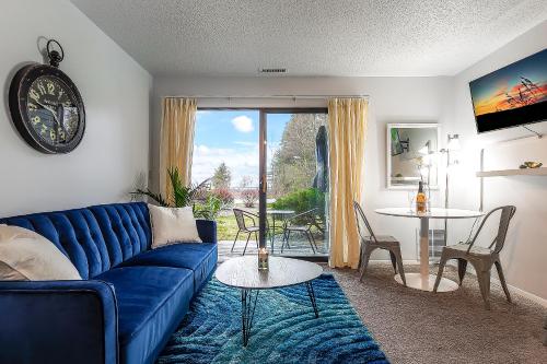 a living room with a blue couch and a table at Beautiful Lake View Studio Condo at The Shores in Traverse City