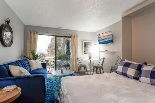 sala de estar con sofá azul y mesa en Beautiful Lake View Studio Condo at The Shores, en Traverse City