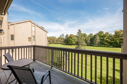 a balcony with a table and chairs and a view at Beautiful 2BDR Loft Suite at Golf Course Condo 5549 in Traverse City