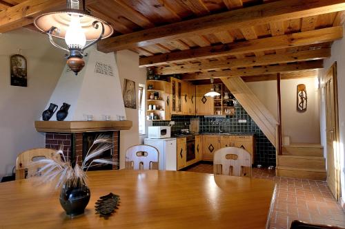 a kitchen with a wooden table and a fireplace at Počitniška hiša Car in Dobrovnik