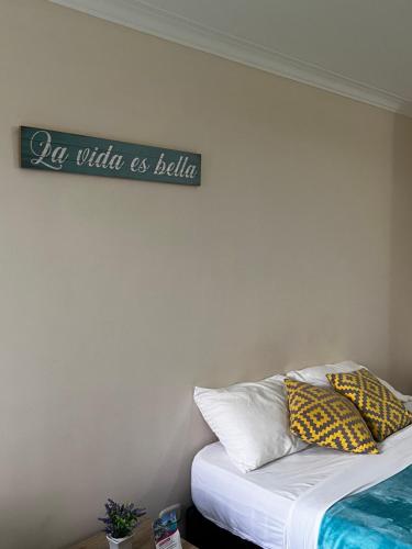 a bedroom with a bed with a sign on the wall at Hotel Casa Confort in Santa Rosa de Cabal