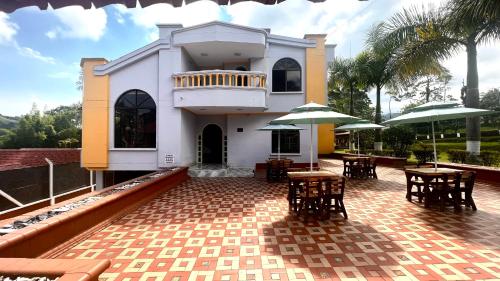 a house with tables and chairs and umbrellas at Hotel Casa Confort in Santa Rosa de Cabal
