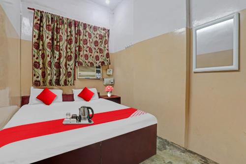 una camera da letto con un letto con cuscini rossi e una finestra di Flagship Hotel Narayani Palace a Kānpur
