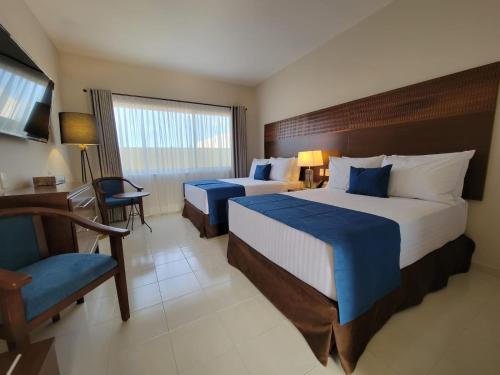 a hotel room with two beds and a chair at Real Cocula in Cocula