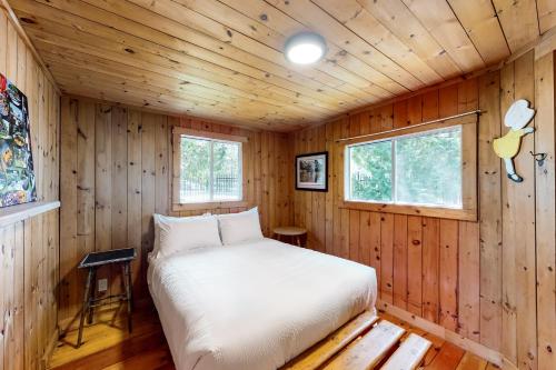 a bedroom with a bed in a wooden cabin at Fiddlers Green Cottage Two in Wasaga Beach