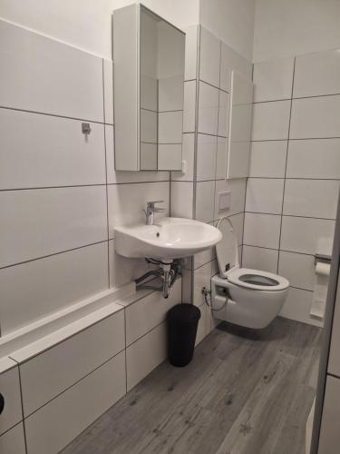 a white bathroom with a sink and a toilet at Studio Apartment 23 - 3R2 in Essen