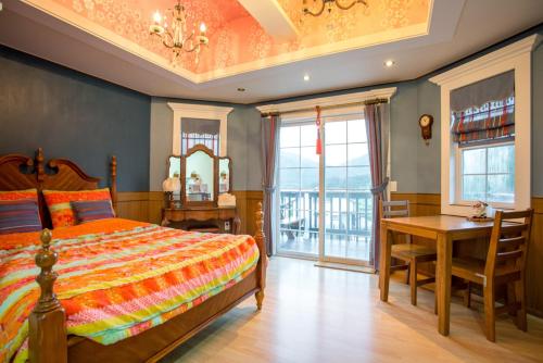 a bedroom with a bed and a table and a desk at Didimdol Pension in Geoje 