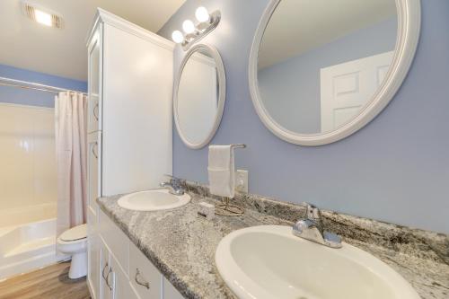 a bathroom with two sinks and a mirror at Coastal Emerald Isle Retreat with Deck and Grill! in Emerald Isle