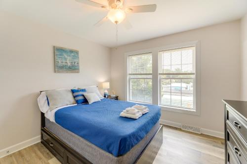 a bedroom with a bed with blue sheets and a ceiling fan at Coastal Emerald Isle Retreat with Deck and Grill! in Emerald Isle