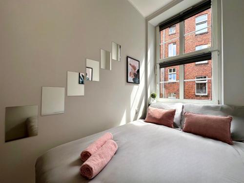 a bedroom with a bed with pink towels on it at MMRent Merci Room in Gdańsk