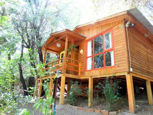 a tree house with a deck and windows at Cabañas Alegria Cajón del Maipo in San José de Maipo