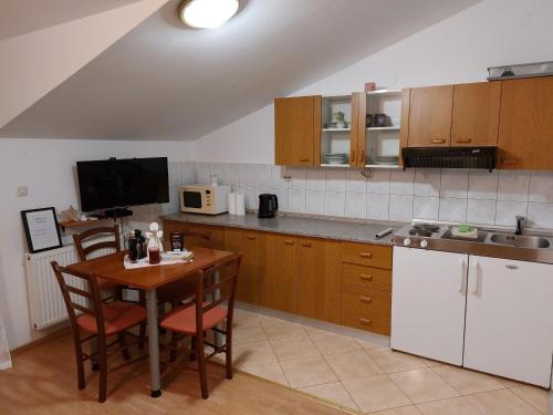 eine Küche mit einem Tisch mit Stühlen und einer Mikrowelle in der Unterkunft Apartments by the sea Okrug Gornji, Ciovo - 9694 in Trogir