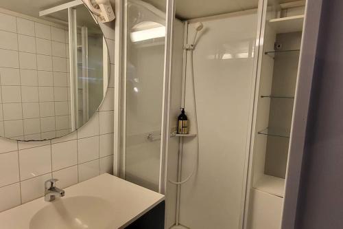 baño blanco con ducha y lavamanos en Central and Large cosey apartment, en Stavanger