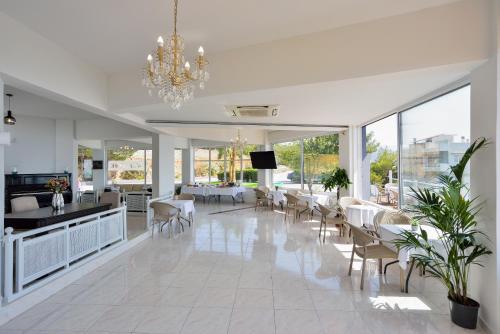 a living room with a chandelier and tables and chairs at Loucerna Suites Chania in Chania Town