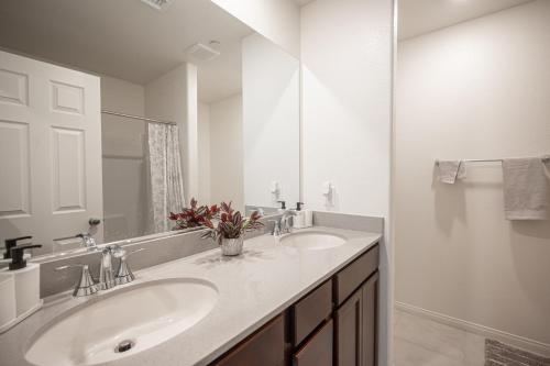 a white bathroom with two sinks and a mirror at Beautiful Brand New 2 Bedroom Vegas Home! Fits 12 or more,15-20 minutes from LV Strip in Las Vegas