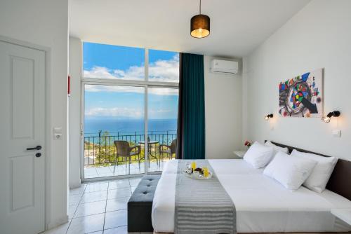 a bedroom with a bed and a view of the ocean at Loucerna Suites Chania in Chania Town