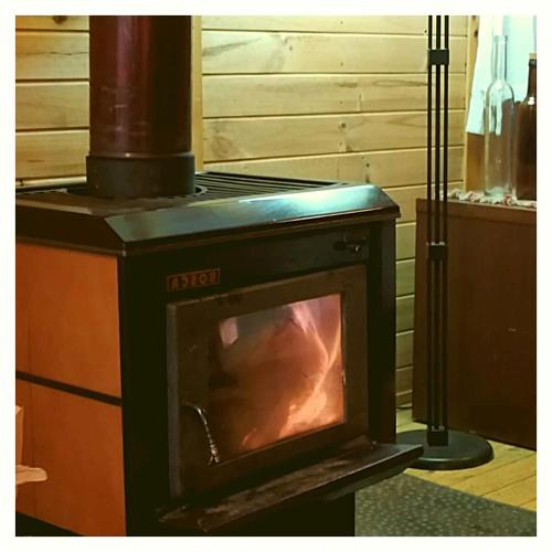 a woodburning stove with a stove in a room at Cabañas Alegria Cajón del Maipo in San José de Maipo
