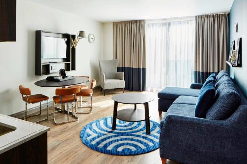 a living room with a blue couch and a table at Residence Inn by Marriott London Bridge in London