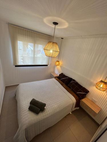 1 dormitorio con 1 cama blanca grande y 2 luces en Mitre en Rosario