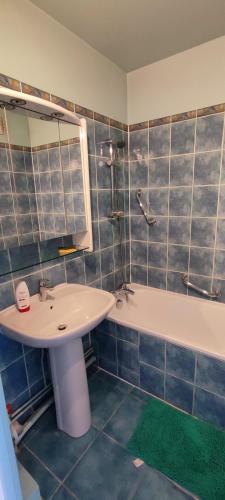 une salle de bain avec un lavabo et une baignoire et un lavabo dans l'établissement Beautiful & cosy 3 bedrooms full accommodation, à Ris-Orangis