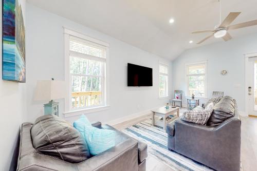a living room with two couches and a flat screen tv at Peace & Sea-Renity in Dauphin Island
