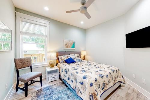 a bedroom with a bed and a tv and a chair at Peace & Sea-Renity in Dauphin Island