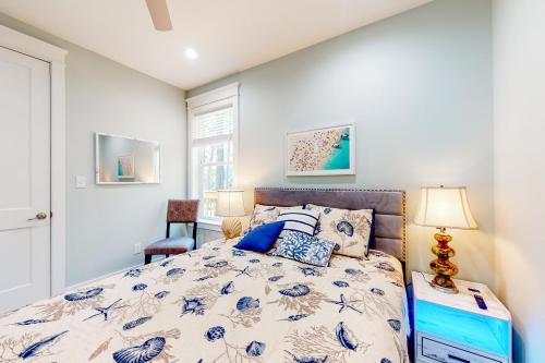 a bedroom with a bed with a blue and white comforter at Peace & Sea-Renity in Dauphin Island