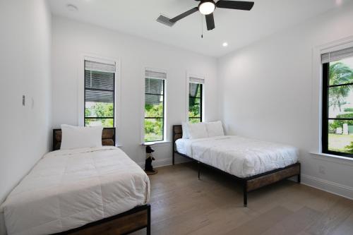 a bedroom with two beds and a ceiling fan at Ocean Estate in Fort Pierce
