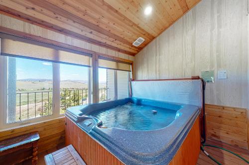 Una gran bañera azul en una habitación con ventana en The Mountainside - Unit B47 en Granby