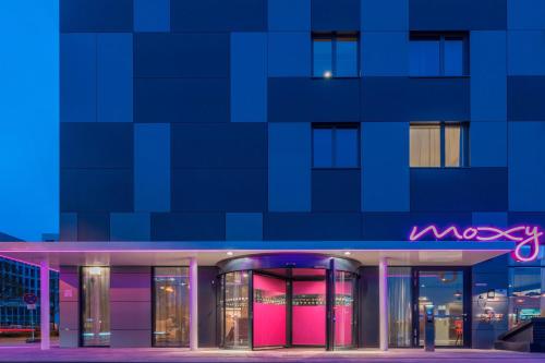 a building with a neon sign in front of it at Moxy Frankfurt Airport in Frankfurt/Main