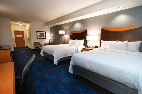 a hotel room with two beds with white sheets at Fairfield Inn & Suites by Marriott Grand Island in Grand Island