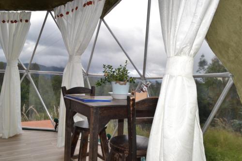 een tafel en stoelen in een yurt met uitzicht bij glamping casa blanca in Guatavita