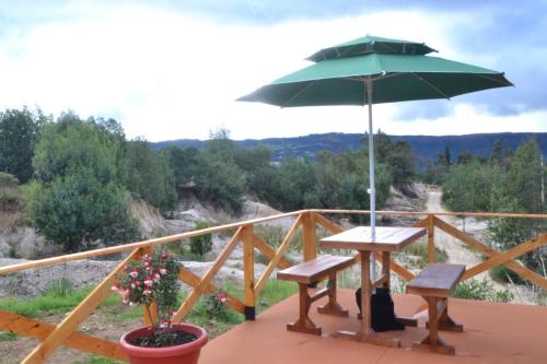 a picnic table and an umbrella on a deck at glamping casa blanca in Guatavita