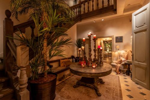a living room with a table and potted plants at The Notary in Bruges