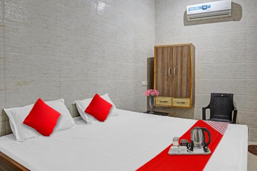 Cette chambre comprend un lit avec des oreillers rouges. dans l'établissement Flagship New Mansi Hotel, à Bilāspur