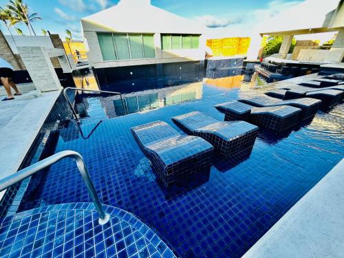 einen Pool mit Stühlen und Tischen in der Unterkunft Solymar Cancún beachfront condos in Cancún
