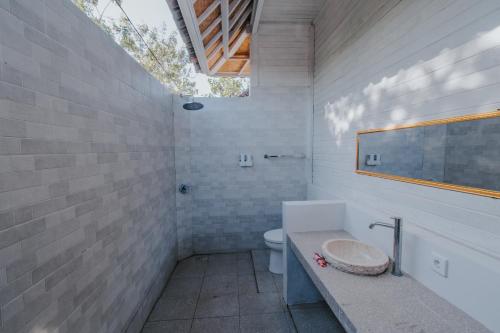 uma casa de banho com um WC e um lavatório em Paluh Beach Huts em Nusa Lembongan